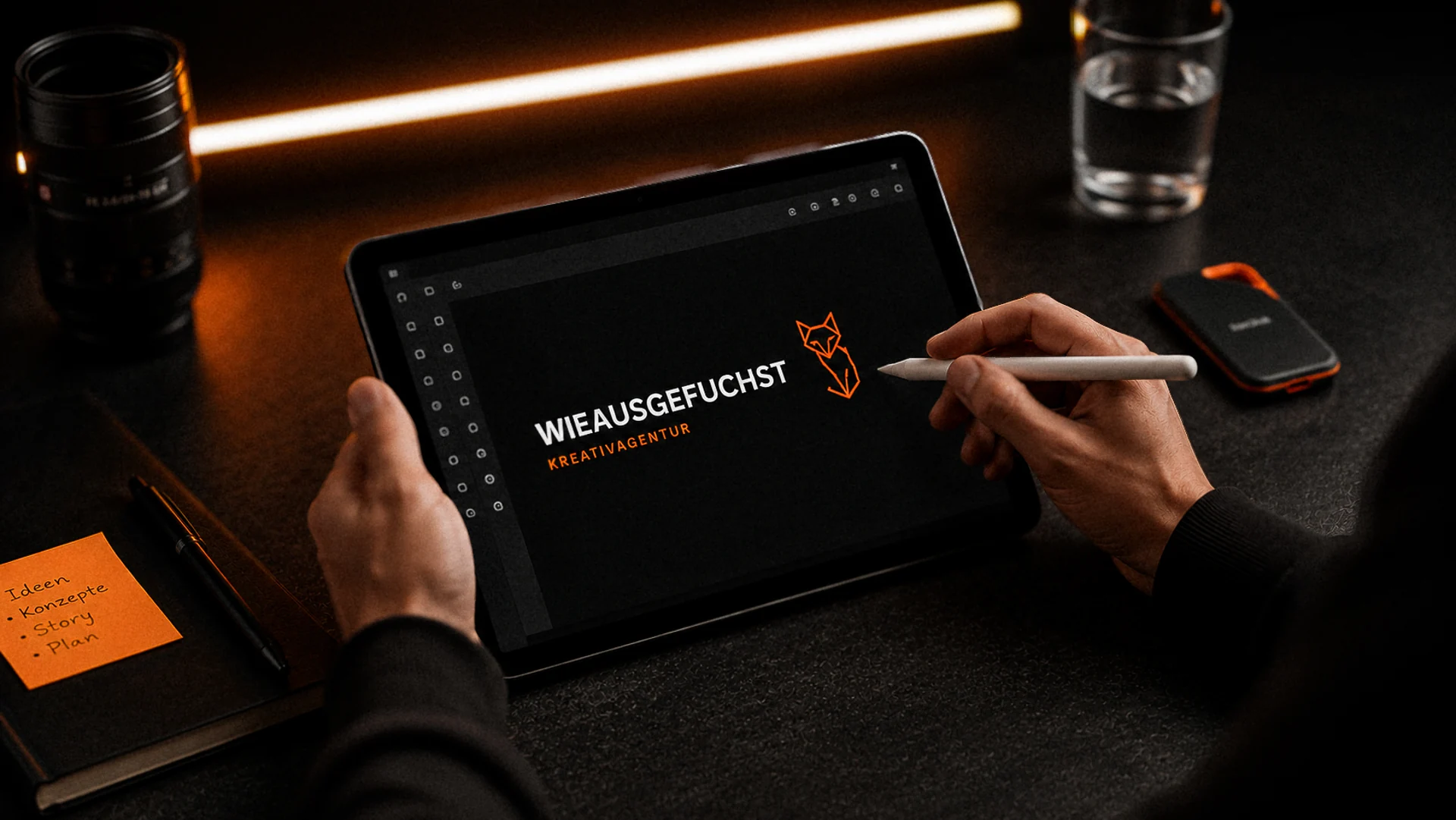 Wieausgefuchst Kreativagentur: Logo-Entwurf auf dem Tablet, daneben Notizen mit Ideen, Konzepten, Story und Plan