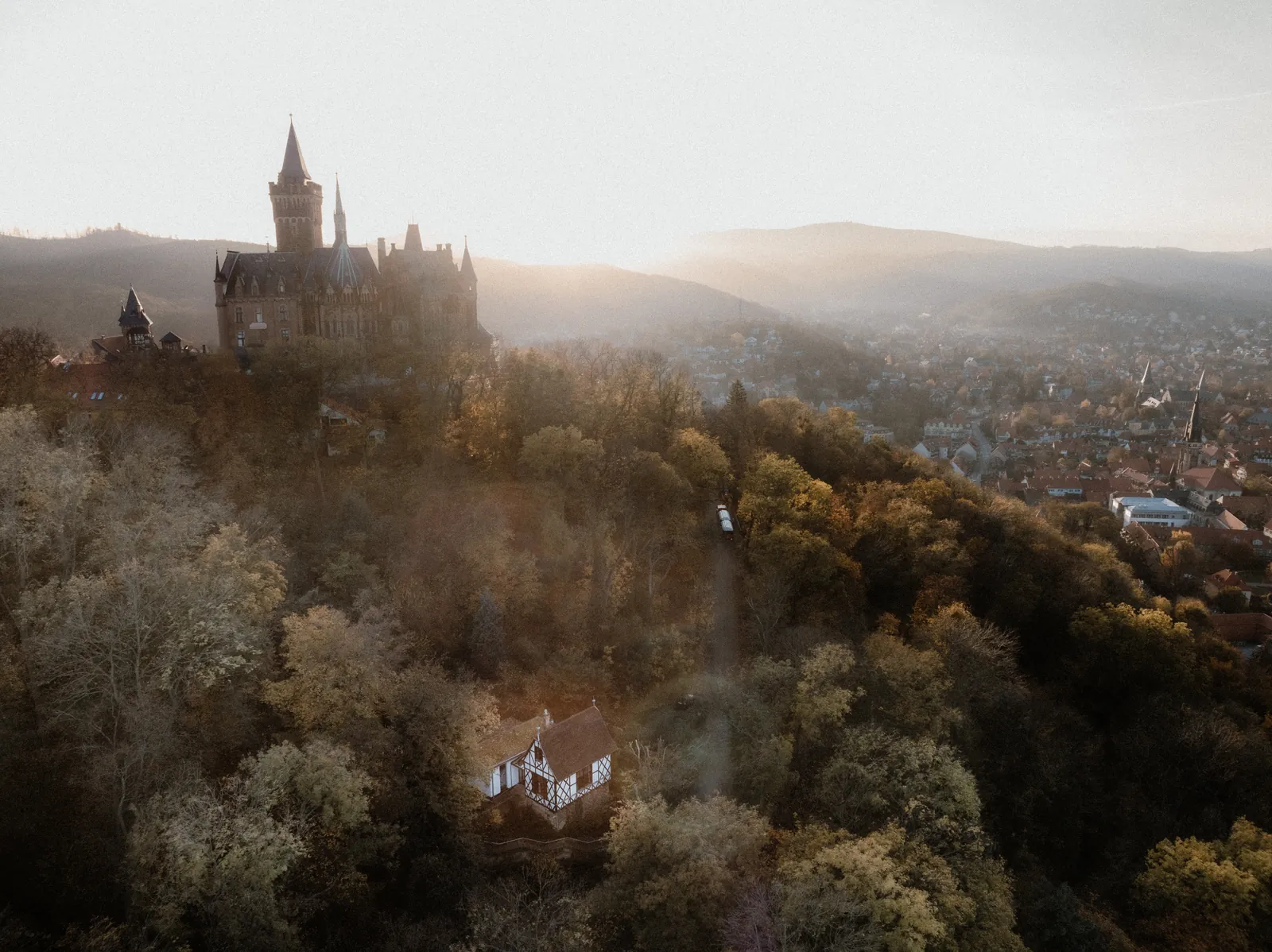 Luftaufnahme von Schloss Wernigerode ueber dem Herbstwald
